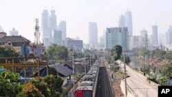 Kereta api bergerak di tengah asap puolusi kota Jakarta, Kamis, 16 September 2021. (AP Photo/Tatan Syuflana) Pemerintah memperpanjang PPKM per level di Jawa dan Bali. 