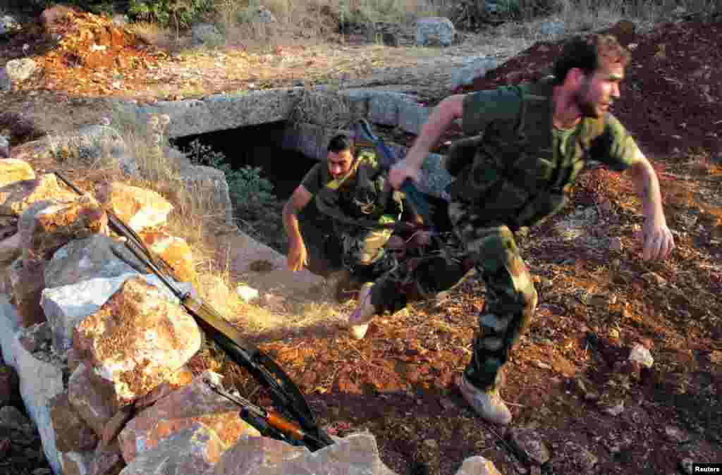 Dua tentara anggota Lasykar Pembebasan Suriah - dari kelompok Brigade Farouq - melakukan latihan militer di Sarmada, dekat provinsi Idlib (9/7).