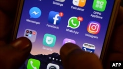 FILE - This photo taken on March 22, 2018 shows apps for WhatsApp, Facebook, Instagram and other social networks on a smartphone.