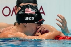 Katie Ledecky, front, of the United States, reacts after winning the women's 1500-meters freestyle final at the 2020 Summer Olympics, July 28, 2021, in Tokyo, Japan.