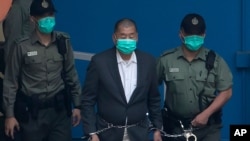 Jimmy Lai, tengah, dikawal oleh petugas Lembaga Pemasyarakatan untuk naik van penjara sebelum muncul di pengadilan, di Hong Kong, 12 Desember 2020. (Foto: AP)