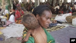 Wata mace daga kudancin Somaliya take rike da danta mai fama da 'yunwar abinci mai gina jiki.