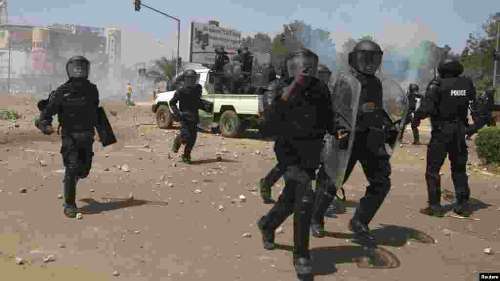 La police accourt après avoir lancé du gaz lacrymogène contre des manifestants qui ont répondu avec des jets des pierres à Ouagadougou, Burkina Faso.