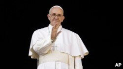 FILE - Pope Francis delivers his "Urbi et Orbi" (to the city and to the world) blessing from the central balcony of St. Peter's Basilica at the Vatican, Dec. 25, 2015.