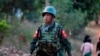 A soldier walks during Myanmar vice-president Sai Mauk Kham (not pictured) visit to a school to meet with government workers who fled from Laukkai, in Lashio, Feb. 20, 2015. 