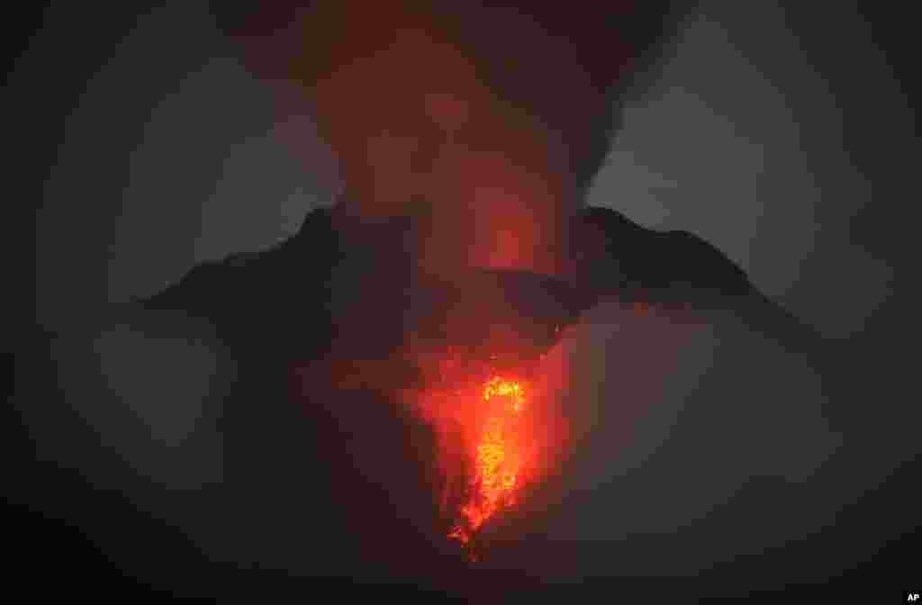 Gunung Sinabung memuntahkan lava dan gas vulkanik terlihat dari Desa Jeraya, Kabupaten Karo, Sumatra Utara.