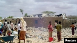 Quelques personnes constatent les dégâts après une frappe aérienne à Dusamareb, Somalie, 1er mai 2008.