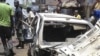 People gather at the bombed office of ThisDay, an influential daily newspaper, Abuja, Nigeria, April 26, 2012.