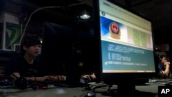 中國北京一名互聯網使用者在網吧的一台標示有警方勸籲小心使用電腦的訊息電腦前使用電腦。（資料圖片）