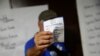 Un ciudadano muestra la boleta con su voto durante la primaria presidencial de la oposición.