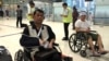 Cambodian opposition​ CNRP lawmakers Nhay Chamroeun (left) and Kong Saphea (right) are seen arriving in wheelchairs at a Bangkok airport on Tuesday, October 27, 2015 after being beaten by protesters in Phnom Penh, Cambodia on Monday. (Courtesy of Nhay Chamroeun) 