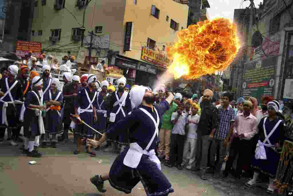 Seorang pemuda Sikh mendemonstrasikan permainan api selama prosesi keagamaan pada malam peringatan ulang tahun kelahiran Guru ajaran Sikh, Ram Das di Amritsar, India.