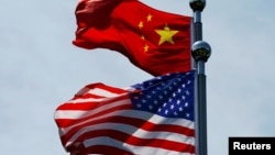 Bendera China dan AS berkibar di dekat The Bund, sebelum delegasi perdagangan AS melakukan pembicaraan di Shanghai, China, 30 Juli 2019. (Foto: REUTERS/Aly Song)