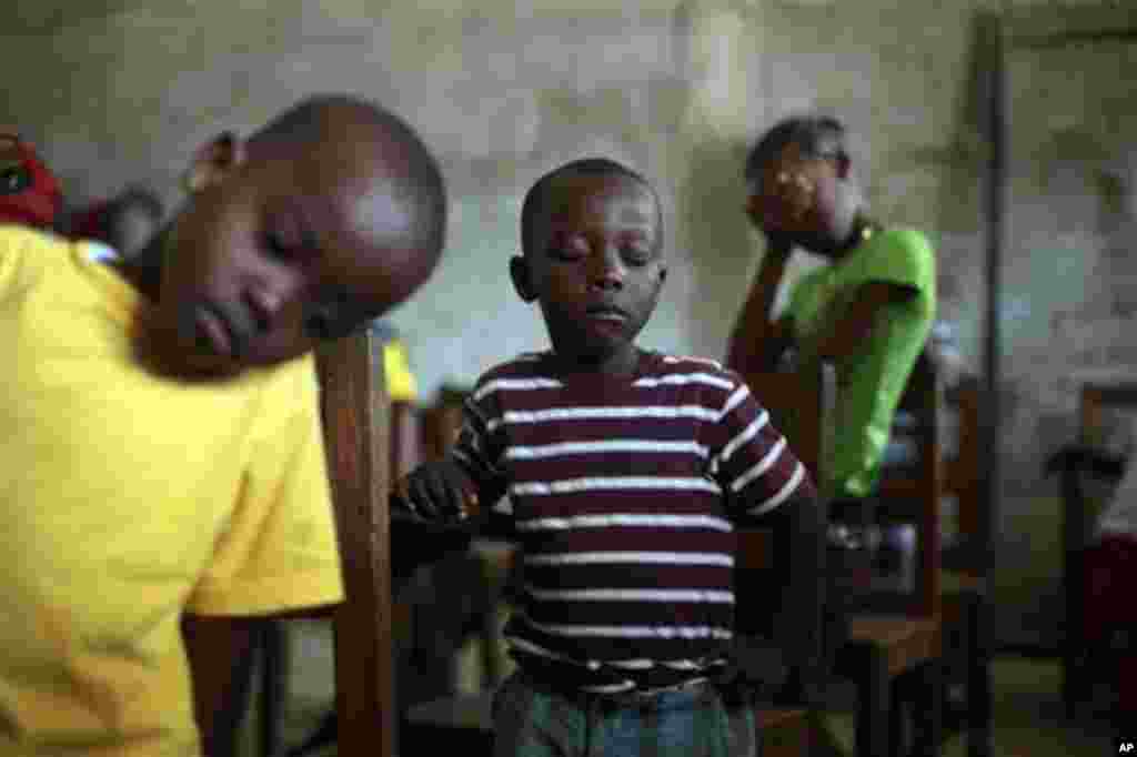 Les enfants prient pendant un culte du dimanche à l'église baptiste Bridgeway dans le quartier Saint-Paul Pont de Monrovia, au Libéria, le dimanche 28 septembre 2014. (AP Photo / Jérôme Delay)