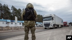 Seorang penjaga perbatasan Ukraina berdiri di wilayah perbatasan antara Ukraina dan Belarus di pos pemeriksaan Novi Yarylovychi di Ukraina, pada 21 Februari 2024. (Foto: AP/Oleksandr Ratushniak)