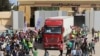 Des travailleurs humanitaires égyptiens célèbrent le retour de Gaza d'un camion en Égypte par le poste frontière de Rafah, le 21 octobre 2023.
