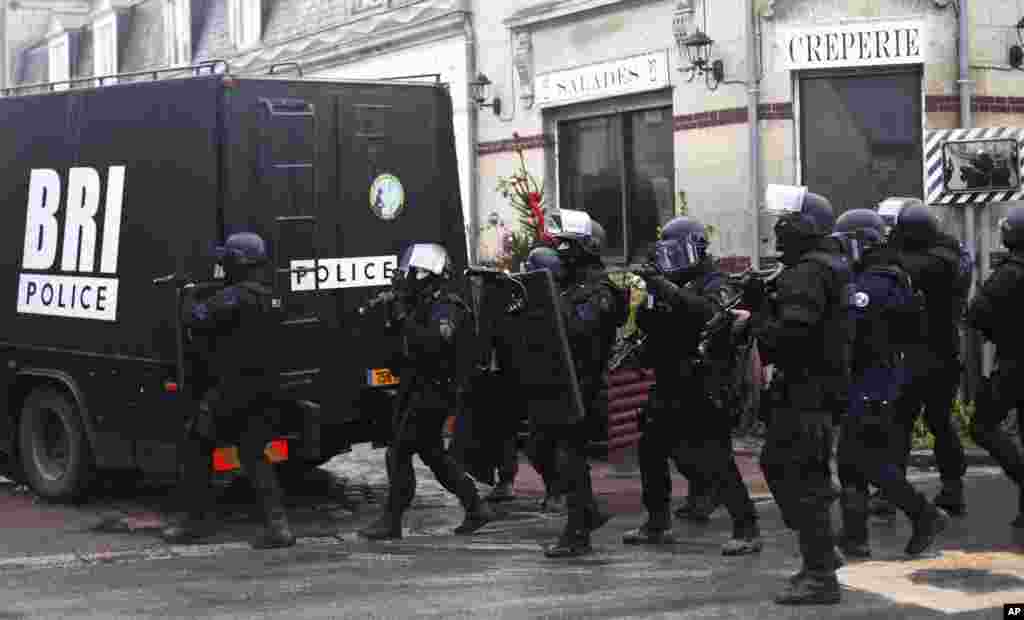French riot officers patrol in Longpont, north of Paris. Police hunted down the two heavily armed brothers suspected in the massacre to make sure they don't strike again.