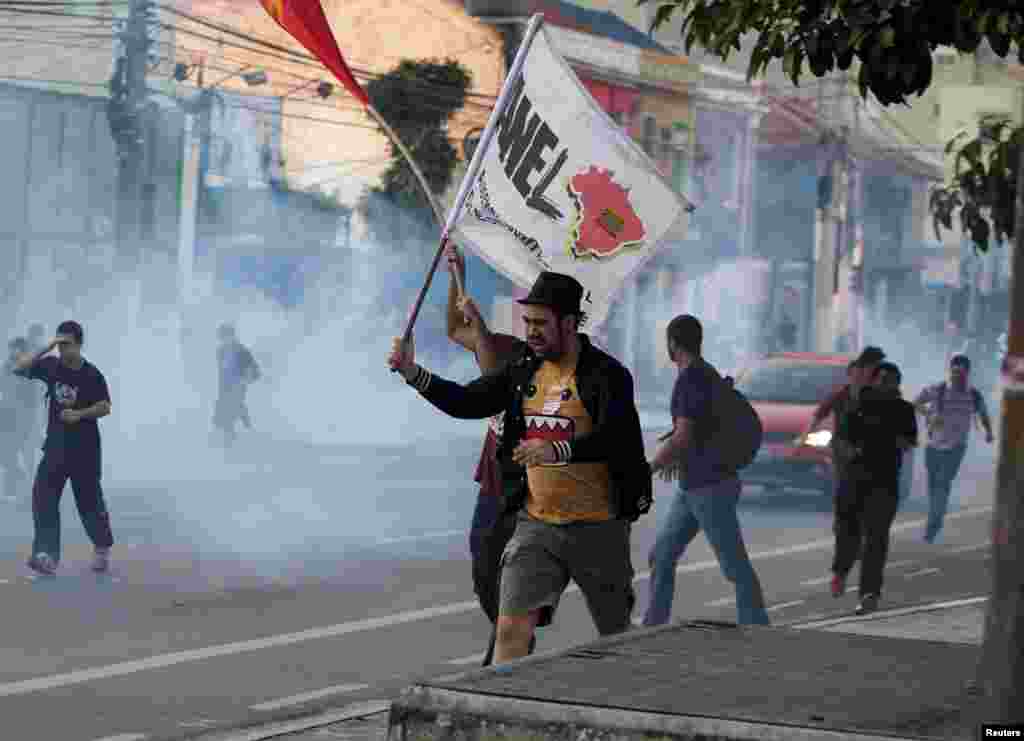 Para demonstran lari dari gas air mata yang disemprotkan polisi di luar stasiun kereta bawah tanah dalam pemogokan pekerja metro hari ke lima di Sao Paulo, Brazil (9/6).