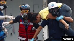 Seorang pengunjuk rasa digendong oleh anggota-anggota relawan perawatan utama selama rapat akbar menentang pemeritahan Presiden Venezuela, Nicola Maduro, di Caracas, Venezuela tanggal 1 Juli 2017 (foto: REUTERS/Christian Veron)