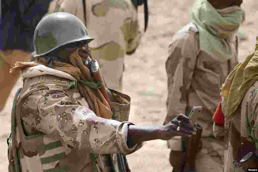 Un soldat nigérien couvre son visage tout en prenant une photo d'un charnier à Damasak, ville récemment reprise de Bokok Haram, au Nigeria, le 20 Mars 2015.