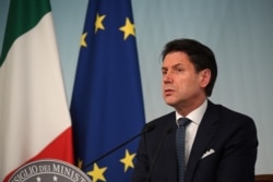 FILE - Giuseppe Conte, then Italy's prime minister, speaks to journalists at an impromptu news conference in Rome, Aug. 8, 2019.