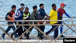 Thai rescue workers carry the body of a victim after a boat capsized off the tourist island of Phuket, Thailand, July 6, 2018. 