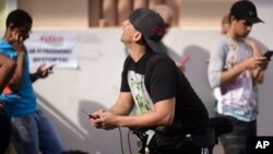 Personas buscan desesperadamente señal celular tras el paso del huracán María en San Juan, Puerto Rico.