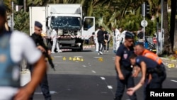 French police secure the area as the investigation continues at the scene near the heavy truck that ran into a crowd at high speed killing scores who were celebrating the Bastille Day July 14 national holiday on the Promenade des Anglais in Nice, France, 