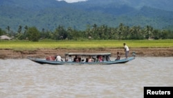 Wara etnis Rohingya mengungsi dengan perahu melewati sungai Buthidaung, Myanmar (foto: ilustrasi). Sedikitnya tiga perahu yang mengangkut pengungsi Rohingya dari Myanmar ke Bangladesh tenggelam, menewaskan 26 orang. 