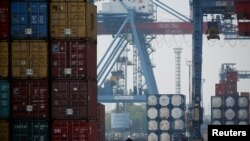 Ilustrasi - Seorang pekerja mengendarai sepeda motor melewati tumpukan peti kemas di Terminal Peti Kemas IPC pelabuhan Tanjung Priok di Jakarta, 4 November 2021. REUTERS/Willy Kurniawan