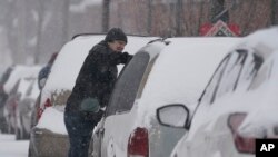 Un automovilista limpia de nieve su vehículo el jueves 3 de febrero de 2022, en Indianápolis, EE. UU.