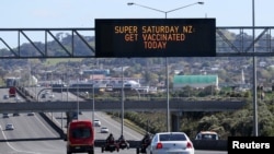 FILE - A sign on an Auckland motorway urges people to get vaccinated at a COVID-19 vaccination clinic during a single-day vaccination drive, in Auckland, New Zealand, Oct. 16, 2021. 