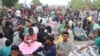 Massa aksi Aliansi Masyarakat Tani Peduli (ARTI) melakukan aksi duduk di badan jalan raya dalam unjuk rasa penolakan tambang emas di desa Siney Kecamatan Tinombo Selatan, Kabupaten Parigi Moutong, Sulawesi Tengah, pada 12 Februari 2022. (Foto: Humas Polda