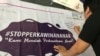 Seorang laki-laki membubuhkan pesan menolak perkawinan anak di atas spanduk yang dipajang dalam Festival Kabupaten/Kota Layak Anak (KLA) yang digelar di Bandung, Minggu (16/12/2018) siang. (Foto: Rio Tuasikal/VOA)