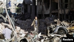 A man walks near debris after an explosion near a security building in Egypt's Nile Delta city of Mansoura in Dakahlyia province, about 120 km (75 miles) northeast of Cairo, Dec. 24, 2013.