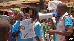 Para petugas kesehatan mengajarkan warga tentang virus Ebola dan bagaimana mencegah infeksi, di Conakry, Guinea. (AP/Youssouf Bah)