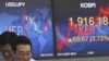 File - Currency traders react in front screens at the Korea Exchange Bank headquarters in Seoul, South Korea.