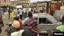 Mutane sun taru a inda aka samu fashewar Bom a Kano. Talata Yuli. 30, 2013.
