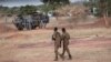 Des soldats burkinabè patrouillent près d'un véhicule blindé français stationné à Kaya, capitale de la région du centre-nord du Burkina Faso, le 20 novembre 2021.