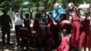 Students at Sekeni Primary School in Chikwawa district hold up educational materials and other supplies they received from UNICEF. (Lameck Masina/VOA)