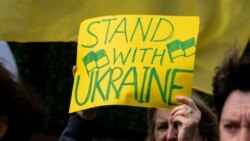 Una mujer sostiene un cartel mientras participa de una manifestación de apoyo a Ucrania frente la sede de la ONU en Nueva York el jueves, 17 de febrero de 2022.
