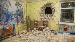 Ladrillos y escombros se mezclan con juguetes debajo de una pared dañada tras un bombardeo en un jardín de infantes en Ucrania el jueves, 17 de febrero de 2022.