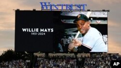 Fans stand for a moment of silence for former Major League Baseball player Willie Mays during the sixth inning of a baseball game between the San Francisco Giants and the Chicago Cubs in Chicago, Illinois, June 18, 2024. Mays has died at age 93.