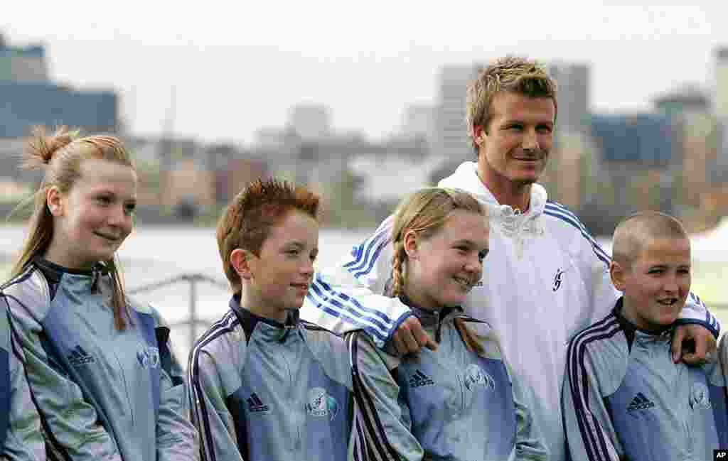 Beckham berpose dengan para siswa dari sekolah lamanya pada peluncuran David Beckham Academy di London, 14 Maret 2005.