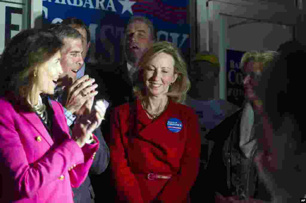 Candidate pour la Maison Blanche, Barbara Comstock, centre, est acclamée pendant qu’elle est introduite pour un discours lors de la compagne appelant les électeurs au vote, le 3 novembre 2014. A gauche Susan Allen, épouse de l’ancien gouverneur George Allen et à droite, Ann Romney, épouse du candidat Mitt Romney. (AP Photo/Cliff Owen)