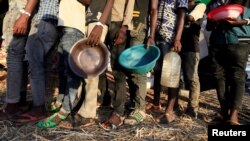 Des réfugiés éthiopiens ayant fui la région du Tigré font la queue pour recevoir une aide alimentaire dans le camp d'Um-Rakoba dans l'État d'Al-Qadarif, à la frontière, au Soudan, le 11 décembre 2020.