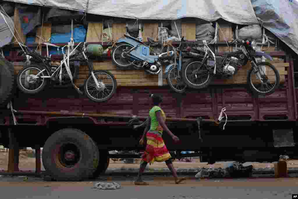 Seorang perempuan berjalan melewati sebuah truk bermuatan barang-barang milik penduduk Muslim PK5 di Bangui (9/4).