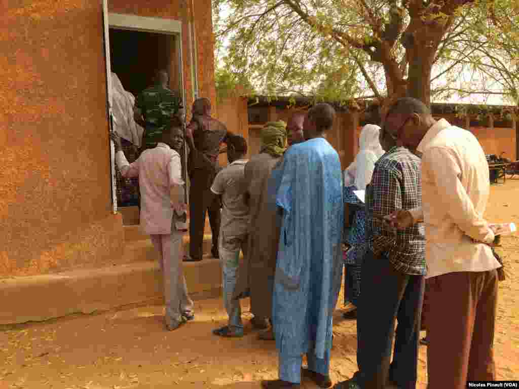 File d'attente devant l'école Yantala Haut CEG 6 de Niamey. Là aussi, une heure de retard environ a été constatée pour l'ouverture, 21 février 2016 (VOA/Nicolas Pinault)