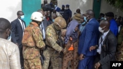 Personel keamanan mengawal tersangka penyerangan (tengah) dari Masjid Agung Fayçal di Bamako, Mali, 20 Juli 2021. Dua pria mencoba menikam Presiden sementara Mali, Kolonel Assimi Goita, saat salat Iduladha di masjid tersebut. 