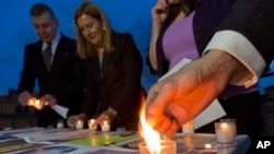 FILE - Members of Survivors Network of those Abused by Priests (SNAP) light candles during a protest to denounce abuses in Rome, April 25, 2014.